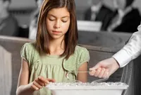A girl taking the sacrament.