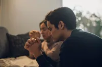 A couple kneel together in prayer