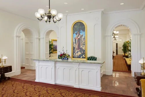 The recommend desk at the entrance of the St. George Utah Temple. The desk itself is white and is flanked by two archways. 