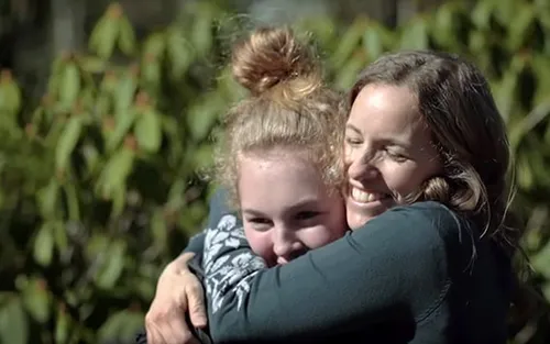 A woman hugs her daughter