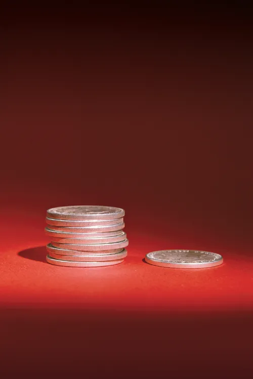 Nine coins in a stack with the tenth coin lying next to them. Illustrates the principle of tithing.