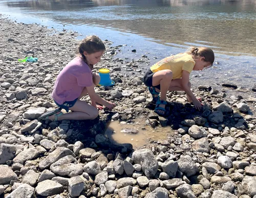 Girls collecting shells along the riverbank