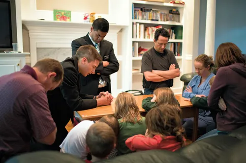 Missionaries praying with family