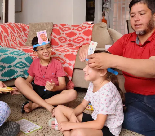 Boy playing a game with his younger sister and dad