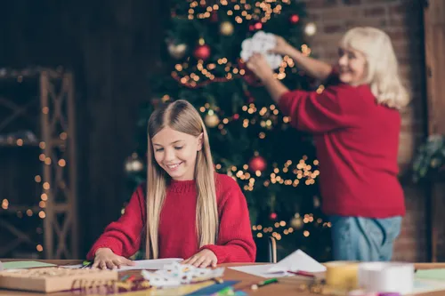 girl making Christmas crafts with grandmother