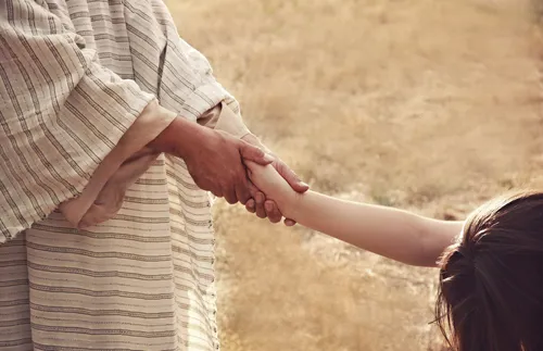 Photo illustration of Christ holding woman’s hand