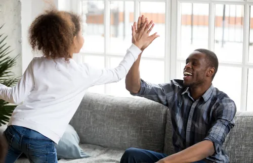 father and daughter giving high fives