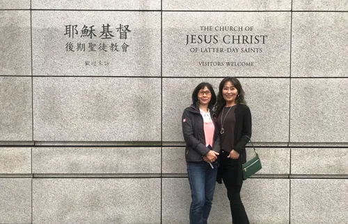 two women standing in front of a Church building