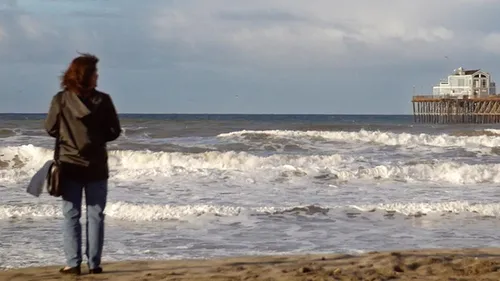 woman looking at pier and ocean
