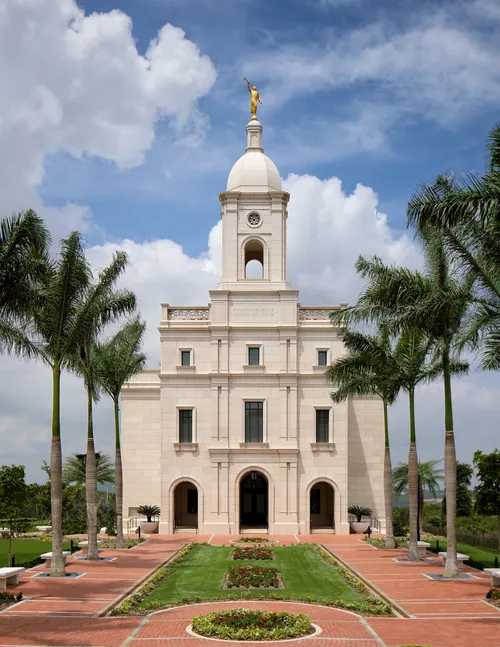 Barranquilla Colombia Temple. This image takes in the temple and temple grounds. This image takes in the front of the temple with the palm trees leading up to the doors.