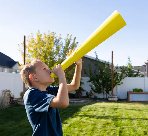 Child blowing into paper trumpet