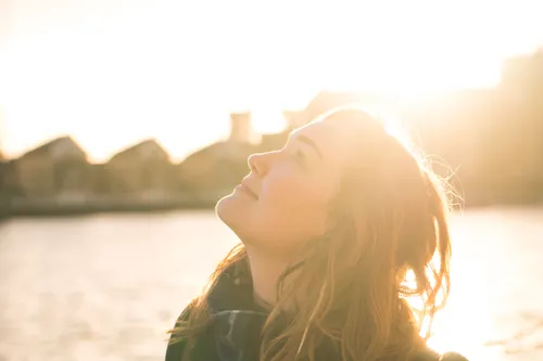 young woman looking up at the sky on a sunny afternoon