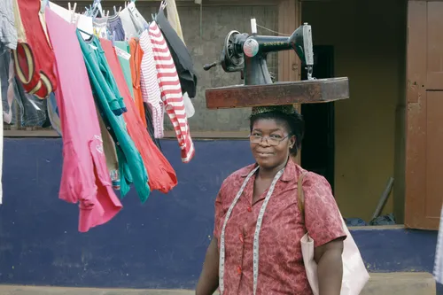 mujer llevando una máquina de coser