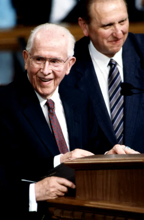 President Ezra Taft Benson standing next to Thomas S. Monson at the podium at his 90th Birthday Fireside, 1989.