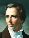 Half-length frontal portrait of the Prophet Joseph Smith, Jr. Joseph’s head is turned to the side in a three-quarter view, right hand on hip and his left hand holds sheets of papers. He is depicted wearing a dark brown suit and a white shirt and tie.