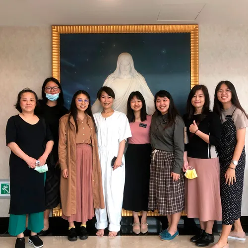 group of people standing in front of image of the Savior