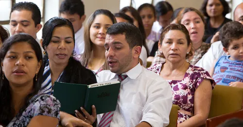 mau ta’ata e hīmene ra i roto i te fare purera’a