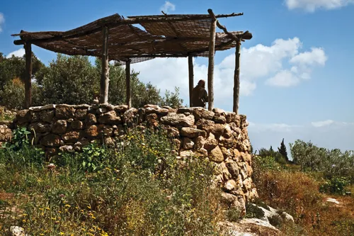 a man standing in a stone watchtower overlooking a valley