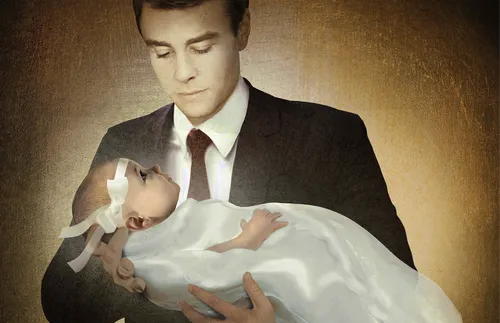 man holding baby in blessing dress