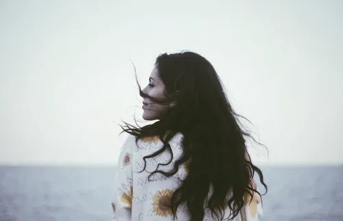 Young adult standing by water