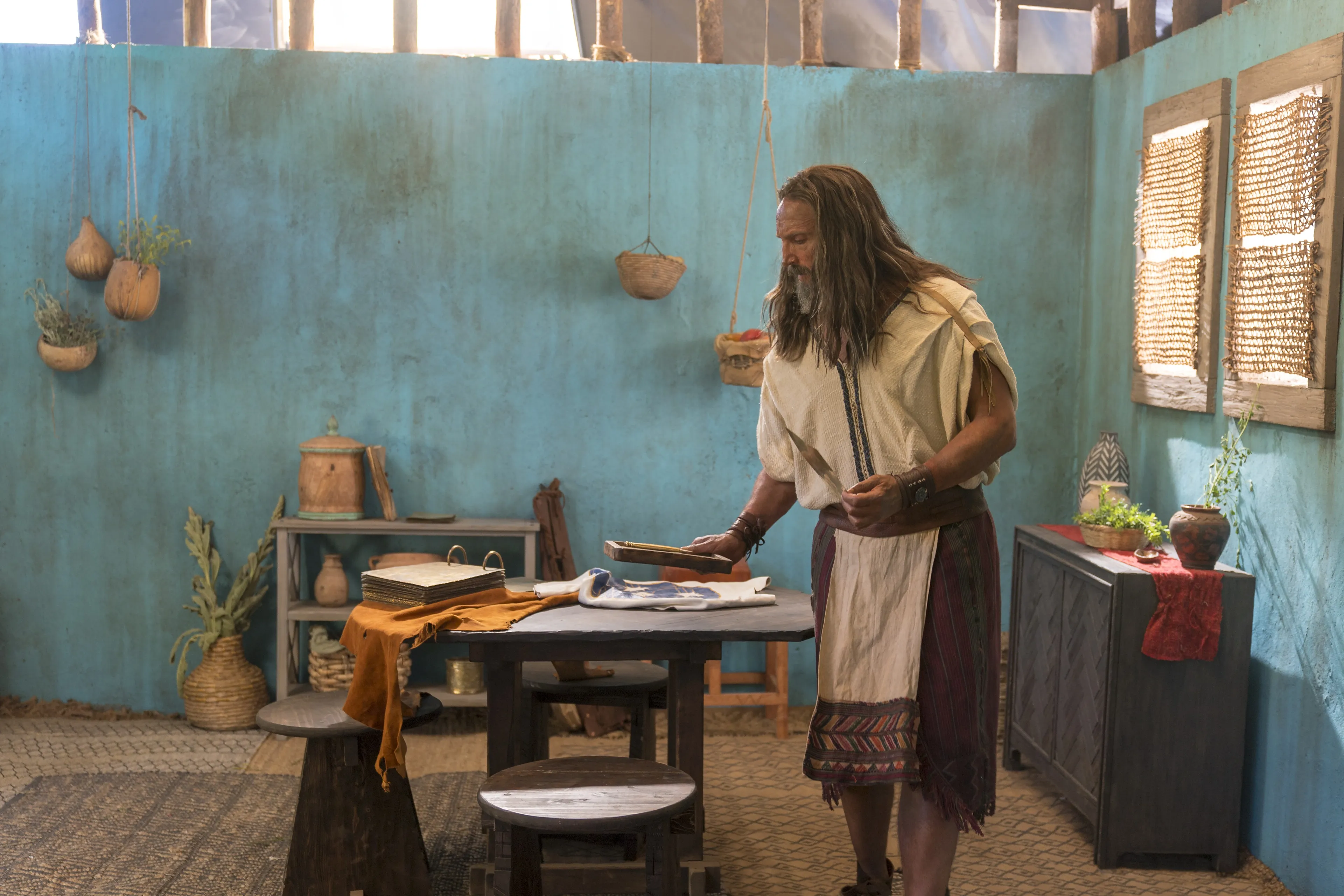 Nephi looks at the metal plates as he prepares to record his testimony.