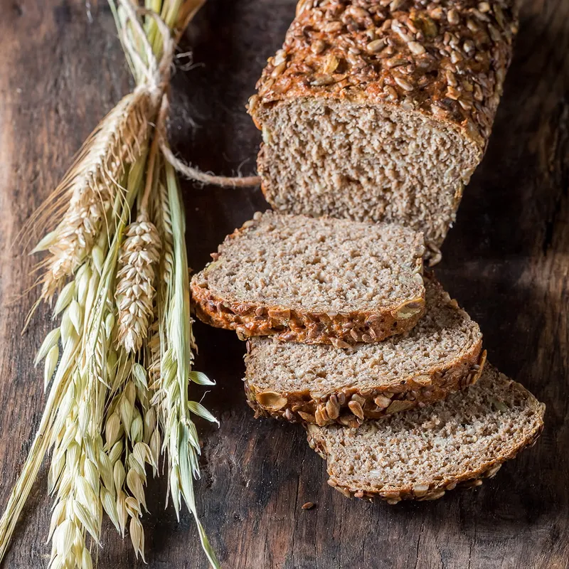 Bread on a table next to a sheaf of grain one of the do's of the word of wisdom