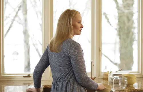 A woman standing at her kitchen sink
