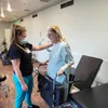 nurse helping a woman with physical therapy
