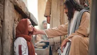Jesus touching the face of a seated woman.