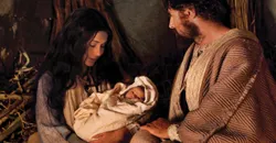 Mary holds the newborn Jesus Christ in the stable with Joseph