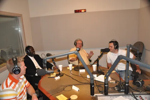 A group of people sitting at microphones around a table.