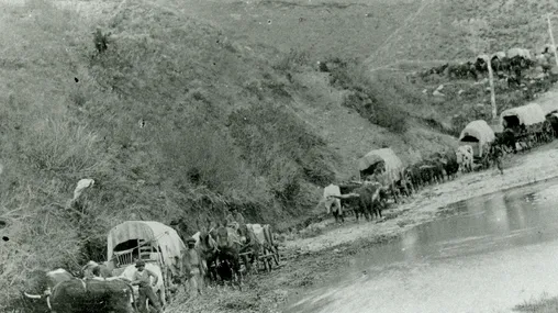 A pioneer wagon train winding down through Echo Canyon. The trail runs along a body of water. Caption on one print reads: "Mormon Emigrants Echo Canyon - 1865."  The July 1993 Ensign dates the image to ca. 1868.
