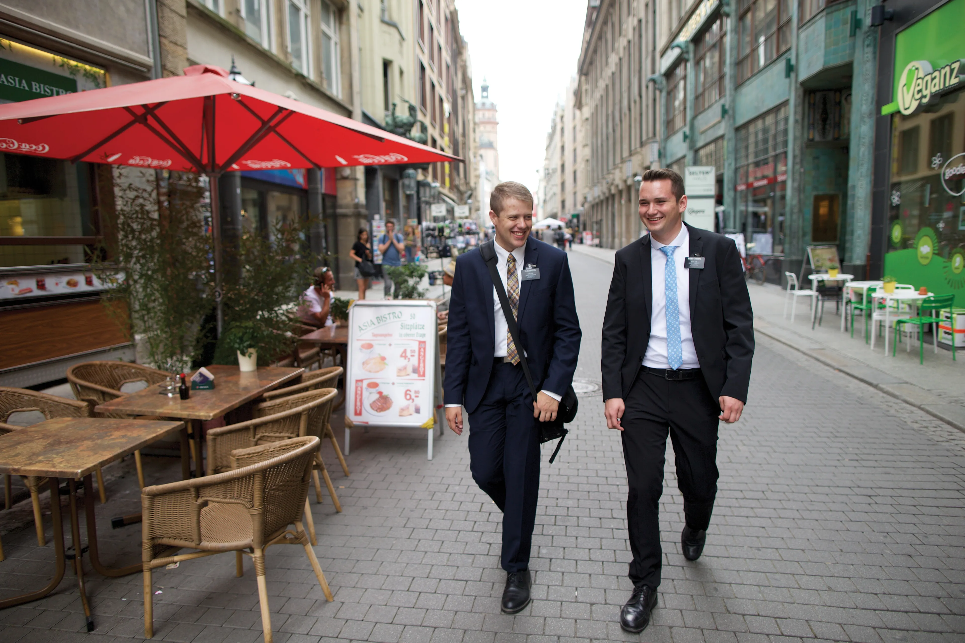 Two elder missionaries walking down a street in Germany.