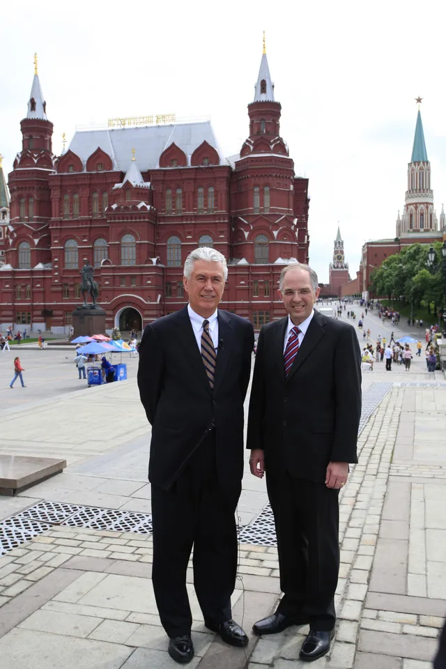 President Dieter F. Uchtdorf and Elder Neil L. Andersen stand together on a city square in Moscow, Russia.