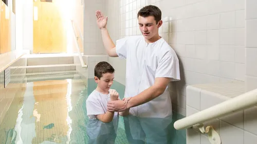 a father baptizing his son in a font