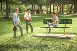Missionaries talk to a man in the park