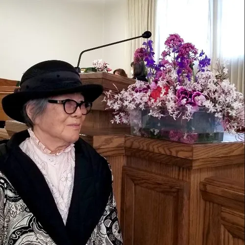 sister standing next to flowers she arranged