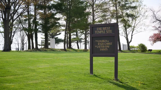 Image of a sign resting on a grassy field that reads, "Far West Temple Site."