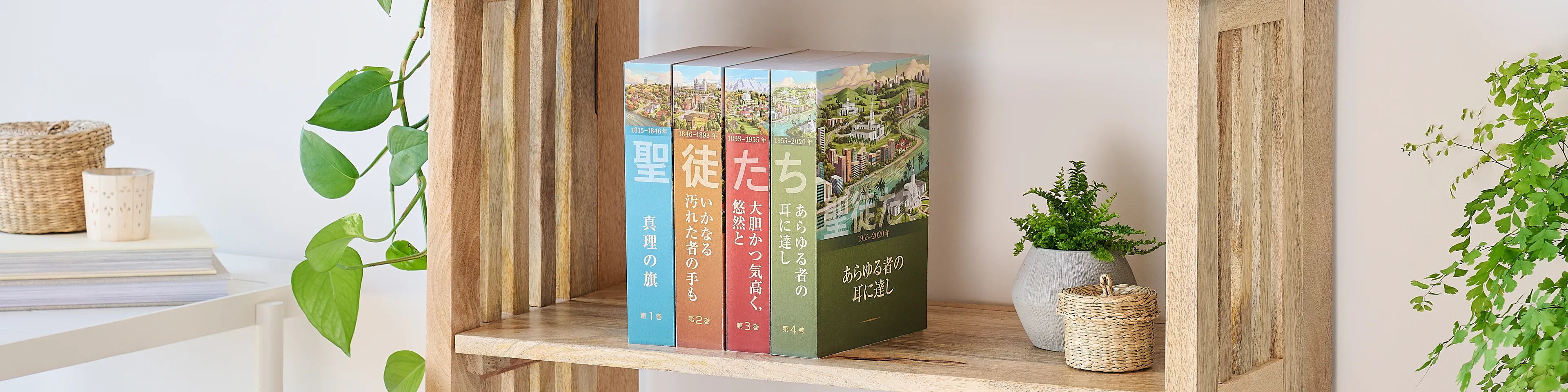 Picture of the book series, 'Saints' volume 1-4 (Japanese edition). Four volumes are arranged on the middle shelf of a wooden bookshelf along with plants, books, a basket, and lamp.