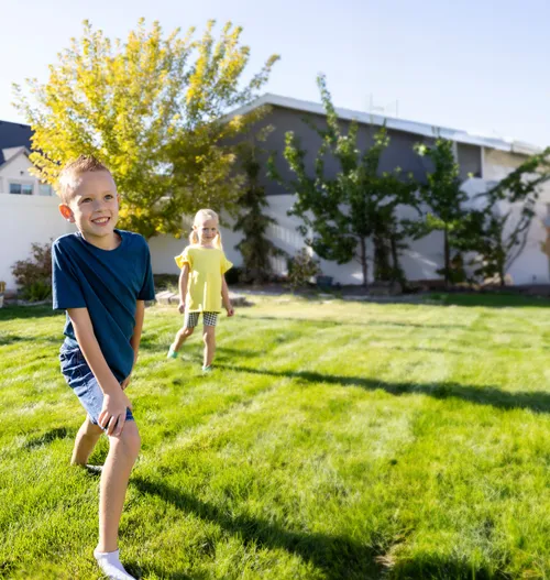 Boy and girl playing on lawn