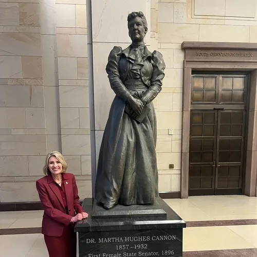 President Camille N. Johnson standing next to statue of Marth Hughes Cannon