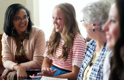 women sitting and smiling together in Relief Society