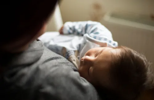 a father holding a sleeping baby