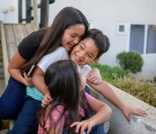 Santiago smiling with his sisters