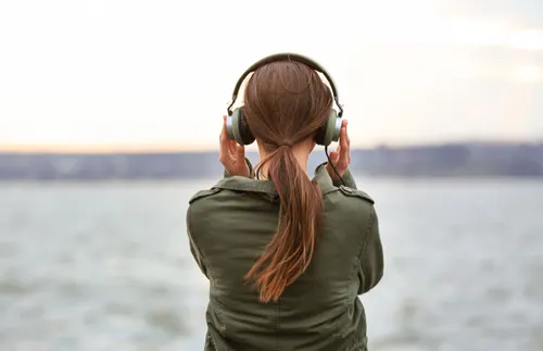 a woman with headphones on gazing into the distance