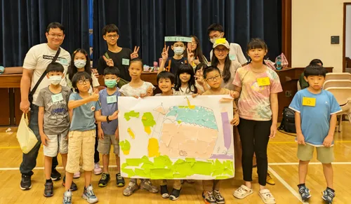 Primary kids holding up a poster with art of the temple