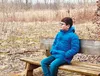 Boy sitting on a bench in a grove