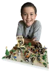 Smiling boy with toy creations of pioneer wagons and handcarts