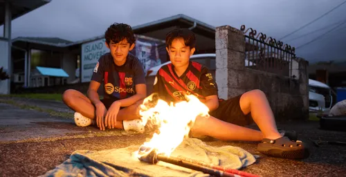 young men sitting in front of a torch