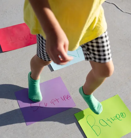 Child’s feet walking on paper squares
